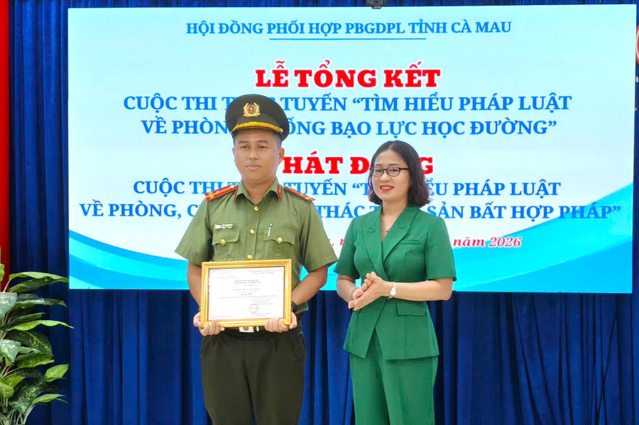 Bà Phạm Thị Ngọc - Phó Giám đốc Sở Tư pháp Cà Mau, trao giải Nhất cho Thượng úy Hứa Thanh Vũ - cán bộ Công an tỉnh Cà Mau.