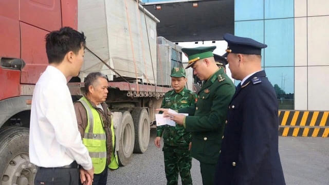 Lực lượng chức năng phối hợp kiểm tra, đối chiếu giấy tờ phương tiện trong quá trình kiểm soát hàng hóa qua khu vực cửa khẩu.