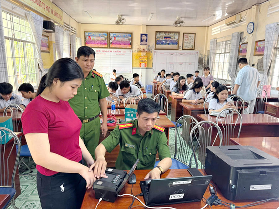 Cán bộ, chiến sĩ Phòng Cảnh sát QLHC về TTXH Công an tỉnh Cà Mau và Công an phường Tân Thành tiếp nhận hồ sơ, hướng dẫn tận tình cho học sinh tại điểm cấp Căn cước lưu động.