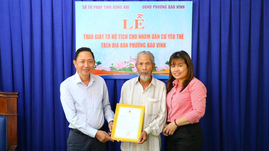 Phó Giám đốc sở Tư pháp Nguyễn Trọng Trí (bên trái) trao giấy khai sinh cho ông Tơn.