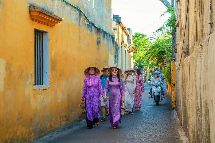 Người dân mặc áo dài đi dạo phố cổ Hội An, tháng 8/2024. Ảnh: Linh Huỳnh