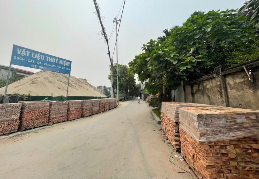 Dọc phố Quang Tiến (phường Tây Mỗ, Hà Nội), khu đất có diện tích lớn trước cổng chùa Linh Thông cũng bị biến thành bãi tập kết cát, gạch xây dựng.