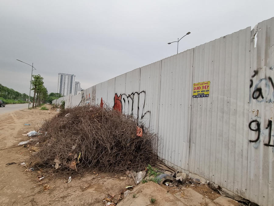 Bao quanh dự án là rác thải và những tấm tôn chắn bị vẽ bẩn.