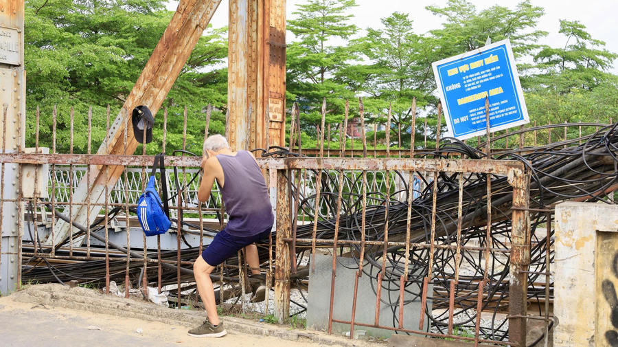Người dân vẫn chui qua khe hàng rào sắt.