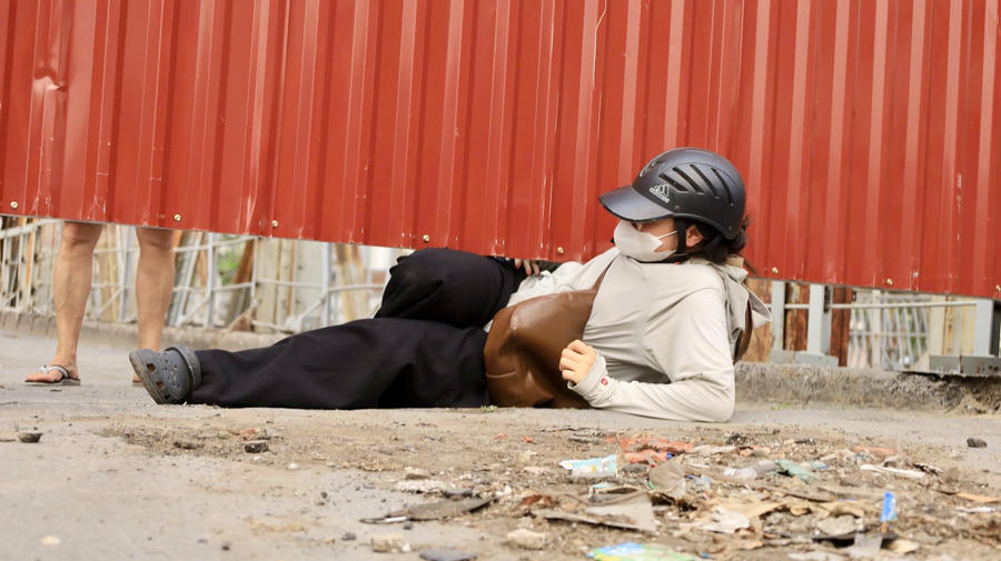 Người dân chui qua các khe hở của rào chắn để di chuyển vào cầu.