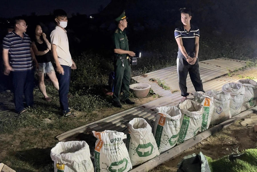 Đối tượng Phạm Văn Hậu và các bao chứa hơn 300 kg chất rắn nghi là thuốc nổ.Ảnh Bộ đội biên phòng Quảng Ngãi.