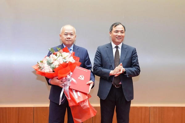 Ông Hoàng Trung Dũng, Phó Trưởng Ban Thường trực Ban Tổ chức Trung ương trao Quyết định và tặng hoa chúc mừng ông Đỗ Thành Trung.