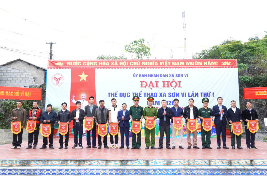 Ban tổ chức trao cờ lưu niệm cho các đoàn tham gia Đại hội Thể dục thể thao xã Sơn Vĩ lần thứ nhất năm 2026. (Ảnh: Hà Linh).