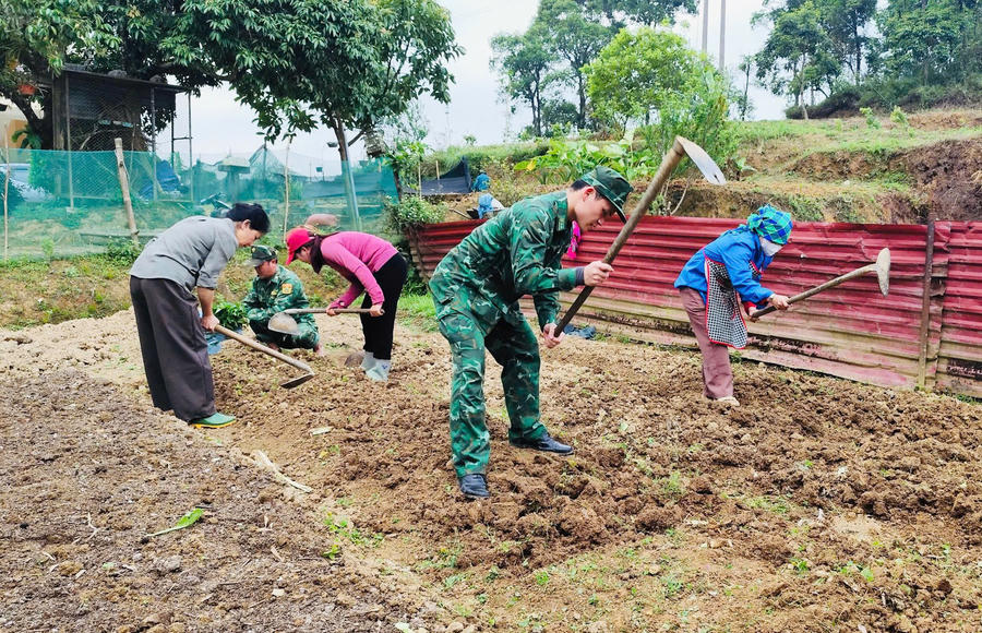 Cán bộ "quân hàm xanh" hướng dẫn nhân dân chuyển đổi cơ cấu cây trồng. (Ảnh: Hoàng Chính).