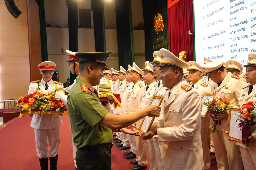 Đại tá Nguyễn Ngọc Quyền, Phó Bí thư Đảng ủy, Phó Giám đốc CATP trao quyết định thăng cấp bậc hàm Thượng tá cho các đồng chí Đội trưởng, Trưởng Công an cấp xã.