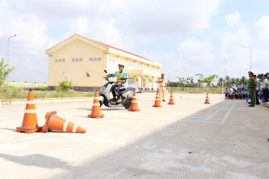 Học sinh thực hành kỹ năng điều khiển xe gắn máy an toàn dưới sự hướng dẫn của cán bộ CSGT.