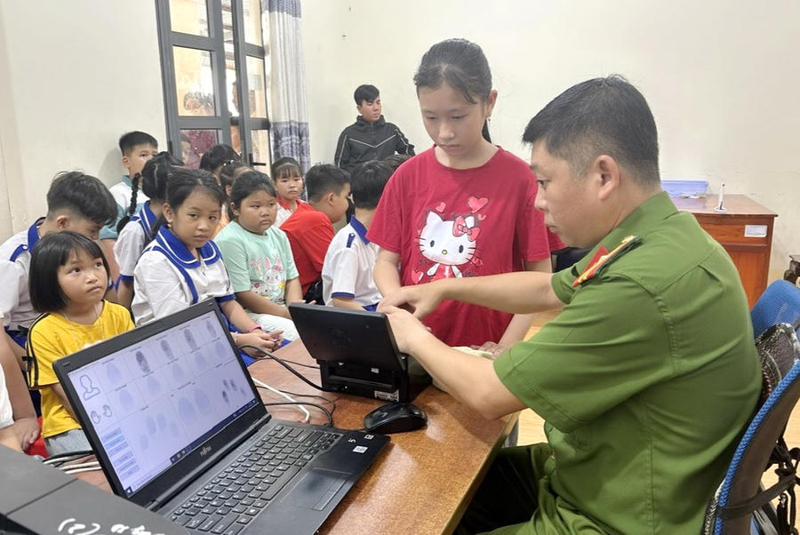 Công an xã Phước Long lăn tay, hoàn thiện hồ sơ cấp căn cước cho trẻ em.