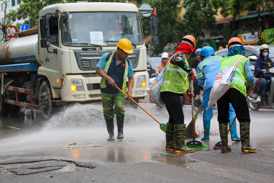 Lực lượng chức năng dọn dẹp đống bùn đất rơi vãi trên đường