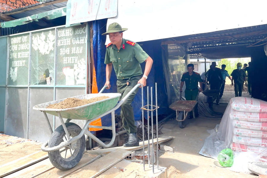 Cán bộ Công an hỗ trợ ngày công vận chuyển vật tư, đắp nền nhà cho hộ ông Nguyễn Văn Bưu, ngụ ấp 4, xã Khánh An.