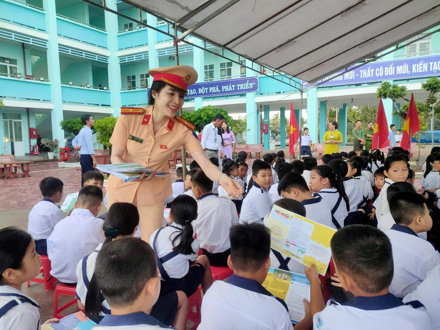 Lực lượng Cảnh sát giao thông phát tờ rơi tuyên truyền, hướng dẫn kỹ năng tham gia giao thông an toàn cho học sinh.