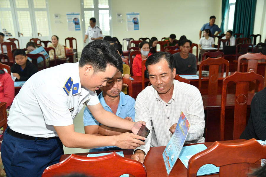 Lực lượng chức năng BTL Vùng Cảnh sát biển 4 hướng dẫn bà con ngư dân quét mã QR tra cứu các quy định về chống khai thác IUU.