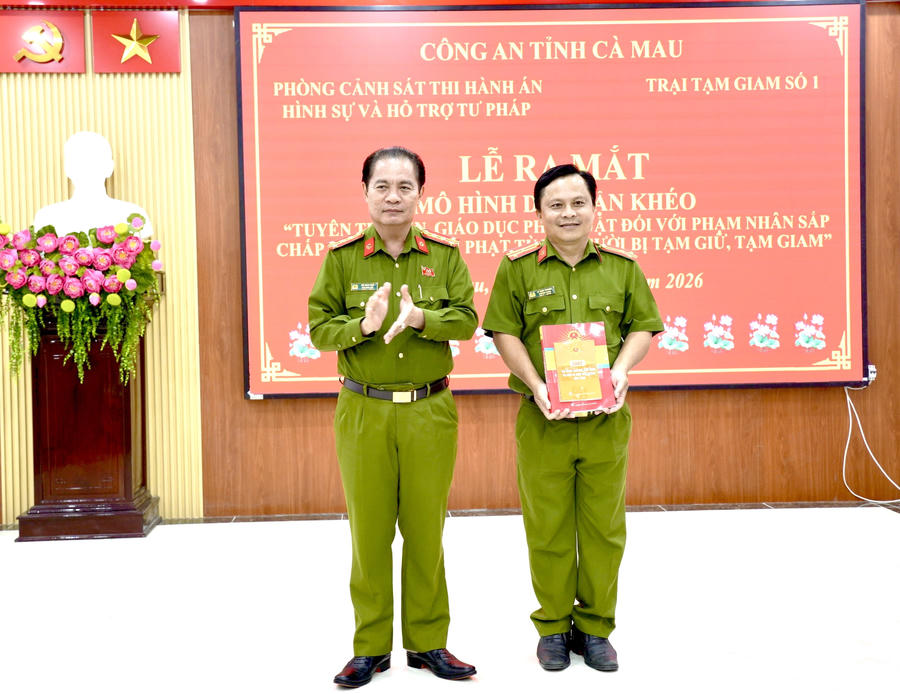 Đại tá Bùi Xuân Khởi - Phó Giám đốc Công an tỉnh Cà Mau trao tặng tượng trưng sách pháp luật cho Trại Tạm giam số 1.