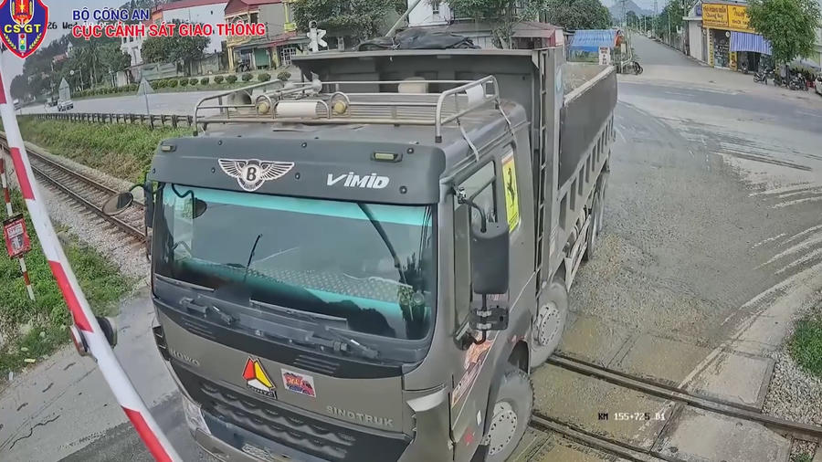 Chiếc xe tải mắc kẹt giữ đường sắt khi rào chắn đã hạ. Hình ảnh cắt từ clip.