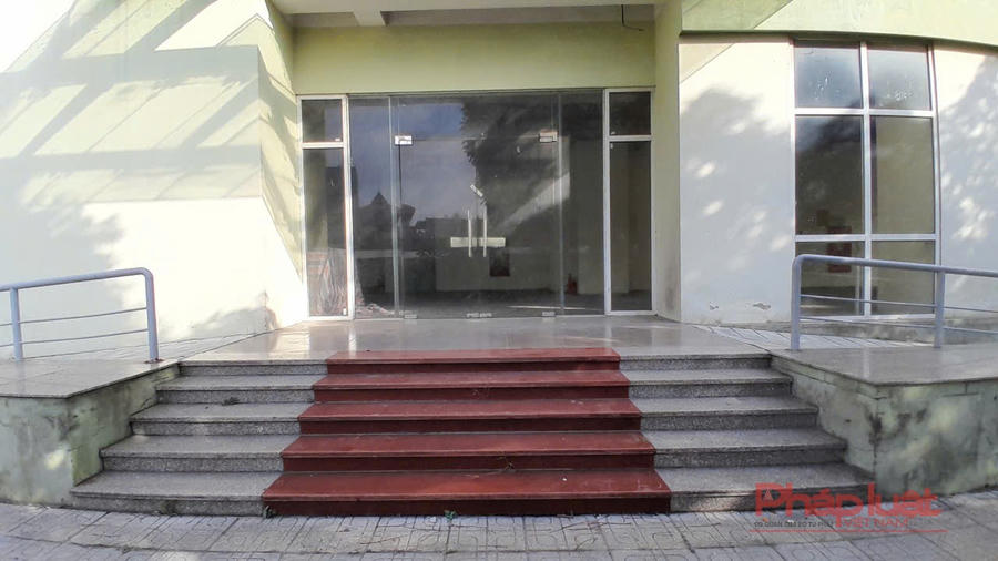 Sảnh ra vào của một trong những toà tái định cư cửa kính luôn khoá và phủ bụi thời gian, tường nứt vỡ, sụt lún.