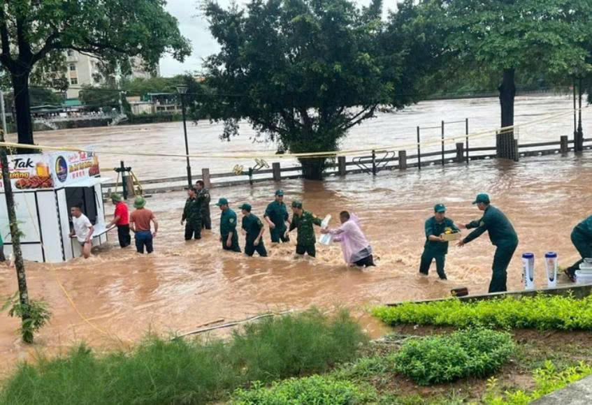 Cán bộ, chiến sĩ Đồn Biên phòng Cửa khẩu quốc tế Móng Cái phối hợp cùng lực lượng chức năng hỗ trợ người dân di dời tài sản, ứng phó mưa lũ.