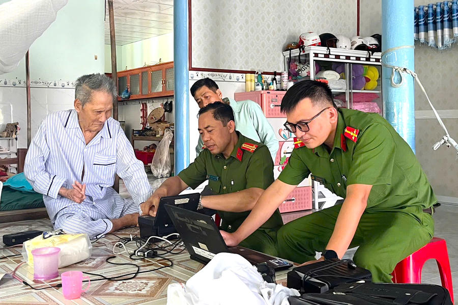 Cán bộ Công an xã Cái Nước cấp căn cước lưu động tại nhà cụ ông Nguyễn Văn Đồng, ấp Đông Mỹ.