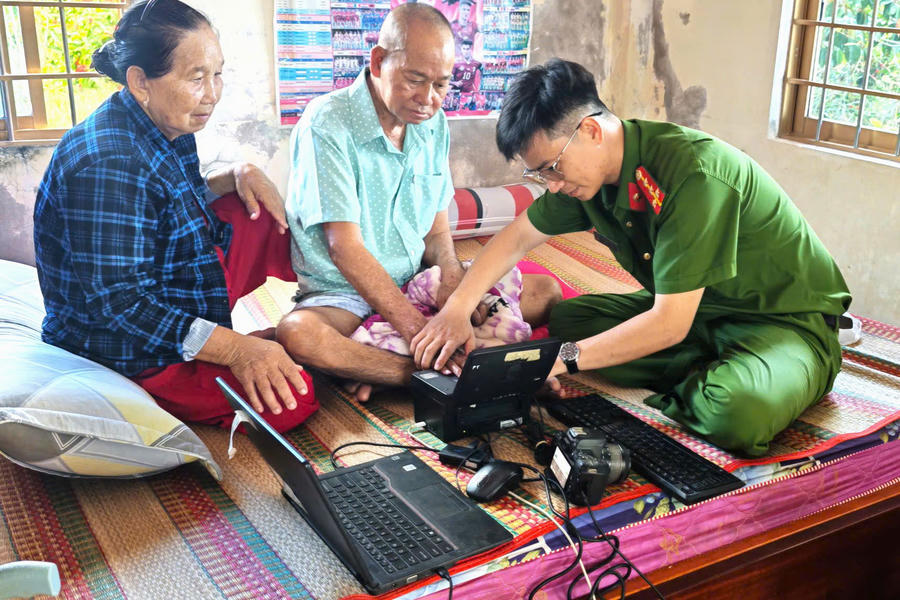 Cán bộ Công an xã Cái Đôi Vàm thu nhận hồ sơ cấp căn cước cho ông Phạm Văn Tới ngay tại giường bệnh.
