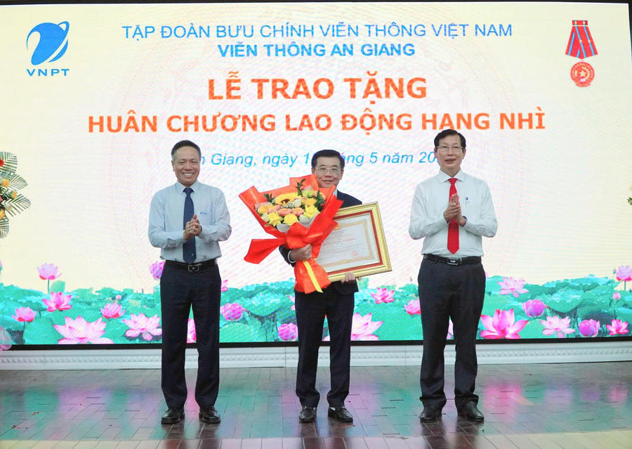 Ông Lê Văn Phước – Tỉnh ủy viên, Phó Chủ tịch UBND tỉnh An Giang và ông Tô Dũng Thái – Chủ tịch Hội đồng thành viên Tập đoàn VNPT trao huân chương lao động hạng nhì và tặng hoa cho ông Trần Thái Tuyên.