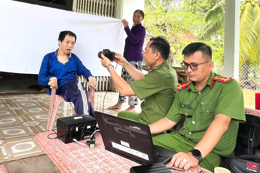 Em Phan Văn Hậu được cán bộ Công an xã Cái Nước hỗ trợ thu nhận hồ sơ cấp căn cước tại nhà.