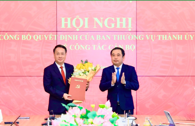Bí thư Thành ủy Hà Nội Trần Đức Thắng trao quyết định và tặng hoa chúc mừng tân Chủ nhiệm Ủy ban Kiểm tra Thành ủy Hà Nội Trần Đình Cảnh.