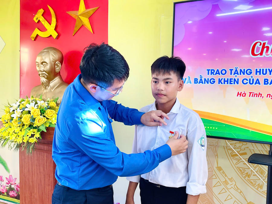 Trao Huy hiệu "Tuổi trẻ dũng cảm" cho em Chu Văn Tuấn Vũ.