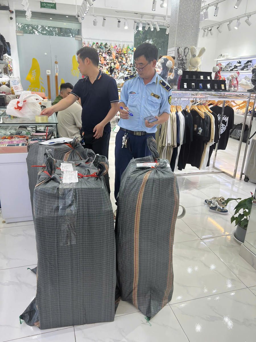 Lực lượng chức năng thu giữ hàng hóa có dấu hiệu giả mạo các nhãn hiệu thời trang nổi tiếng.