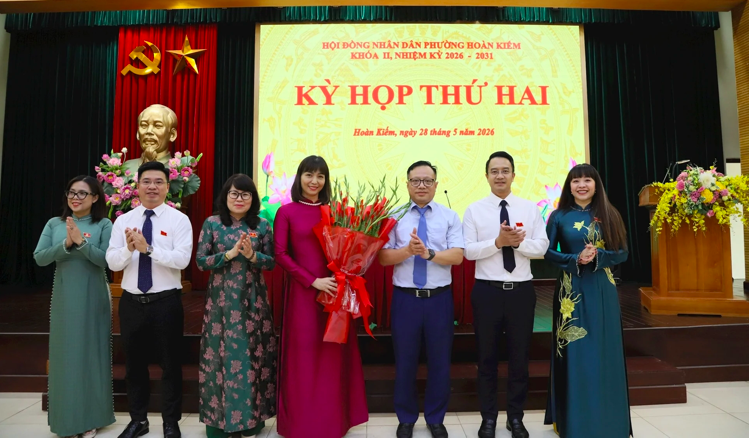 Bí thư Đảng ủy phường Hoàn Kiếm Nguyễn Trúc Anh cùng các đồng chí trong Ban Thường vụ Đảng ủy phường tặng hoa chúc mừng bà Trương Thị Thanh Nhàn.