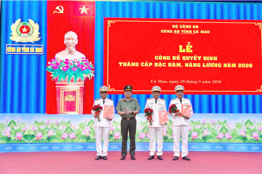 Đại tá Hồ Việt Triều - Giám đốc Công an tỉnh Cà Mau trao Quyết định và tặng hoa chúc mừng các đồng chí được thăng cấp bậc hàm Đại tá năm 2026.