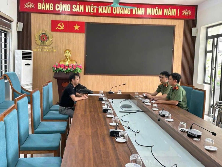 Cán bộ Công an xã làm việc với trường hợp vi phạm.