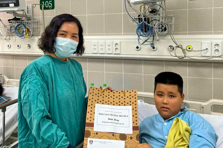 Trung tá Nguyễn Thị Trung, Phó Đội trưởng Đội CSGT đường bộ số 4 trao quà cho bệnh nhi có hoàn cảnh khó khăn.