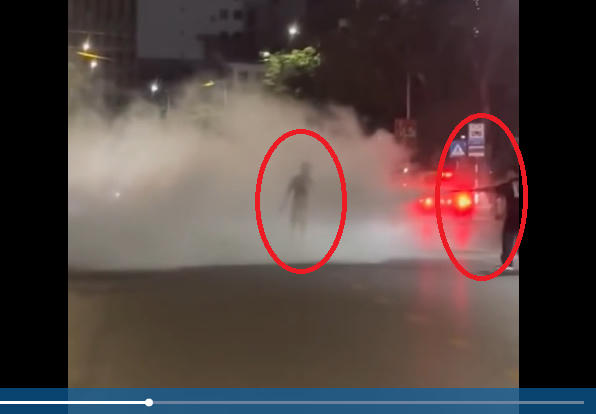 Nam thanh niên dũng cảm dùng bình cứu hỏa đánh lạc hướng kẻ ngáo đá có hành vi nguy hiểm cho người đi đường. Hình ảnh cắt từ clip.
