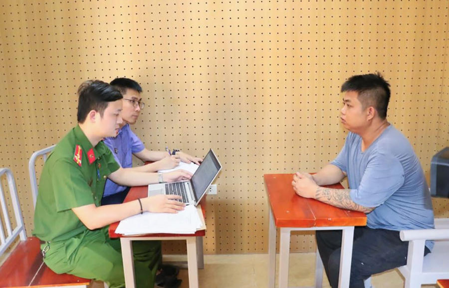 Lê Hồng Phong (phải) làm việc với cơ quan điều tra. Ảnh: Công an cung cấp