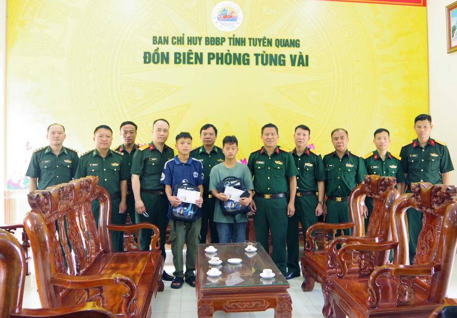 Đoàn công tác tặng quà cho 2 cháu con nuôi Đồn Biên phòng Tùng Vài. (Ảnh: Hoàng Chính).