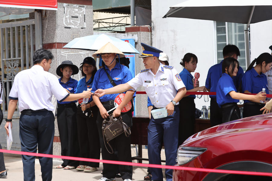 Cán bộ, đoàn viên Hải đội 401 động viên, tặng bút viết cho thí sinh tại điểm thi. (Ảnh: Mạnh Hùng)