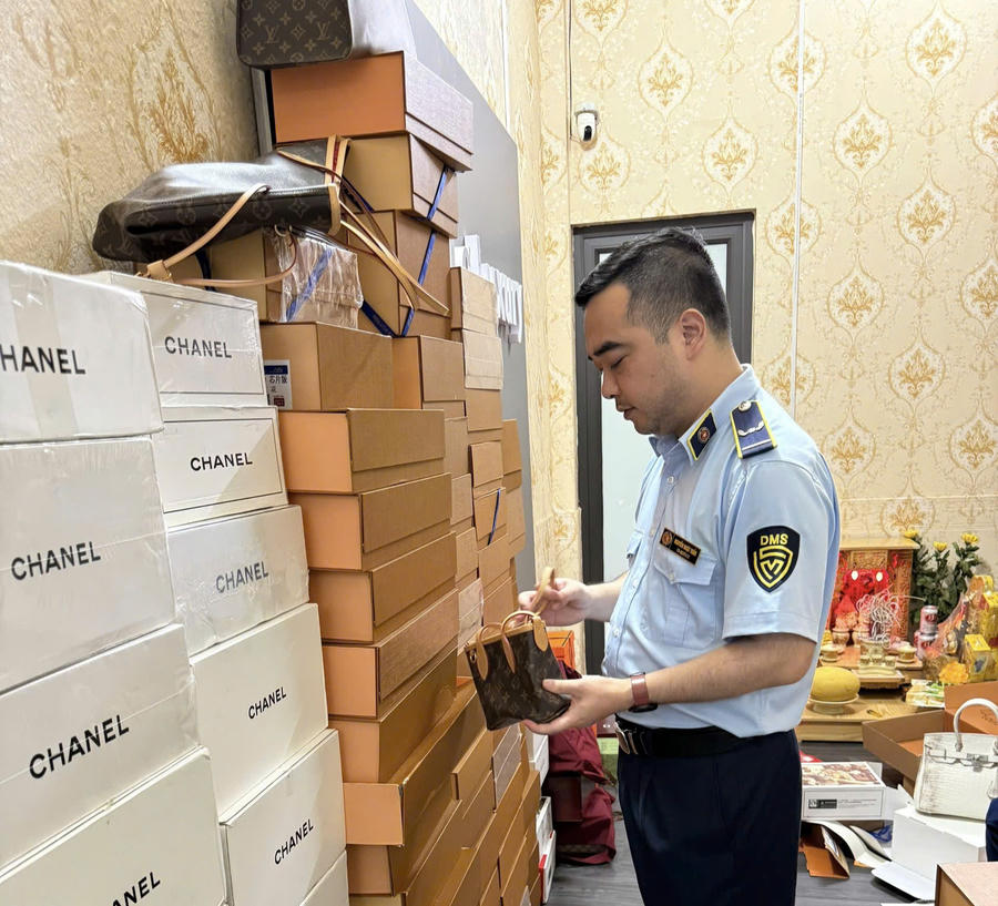 Lực lượng chức năng kiểm tra sản phẩm thời trang tại cơ sở kinh doanh. (Ảnh: dms.gov.vn)