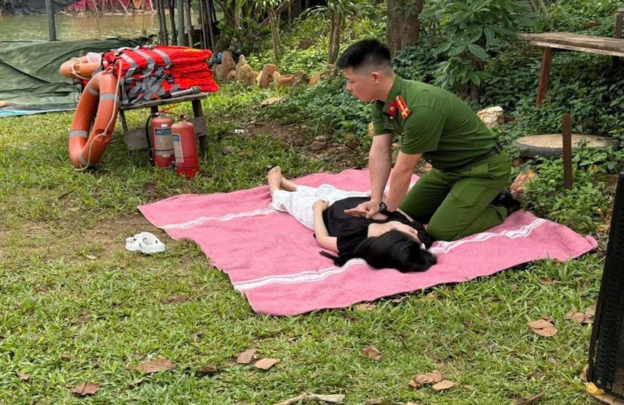 Cán bộ Đội Cảnh sát PCCC và CNCH trên sông hướng dẫn kỹ thuật hồi sinh tim phổi (CPR), sơ cấp cứu ban đầu cho nạn nhân bị đuối nước sau khi được đưa lên bờ