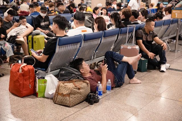 Hình ảnh hành khách vạ vật trong phòng chờ nhà ga do chuyến bay liên tục bị chậm chuyến (ảnh: Báo Tuổi trẻ).