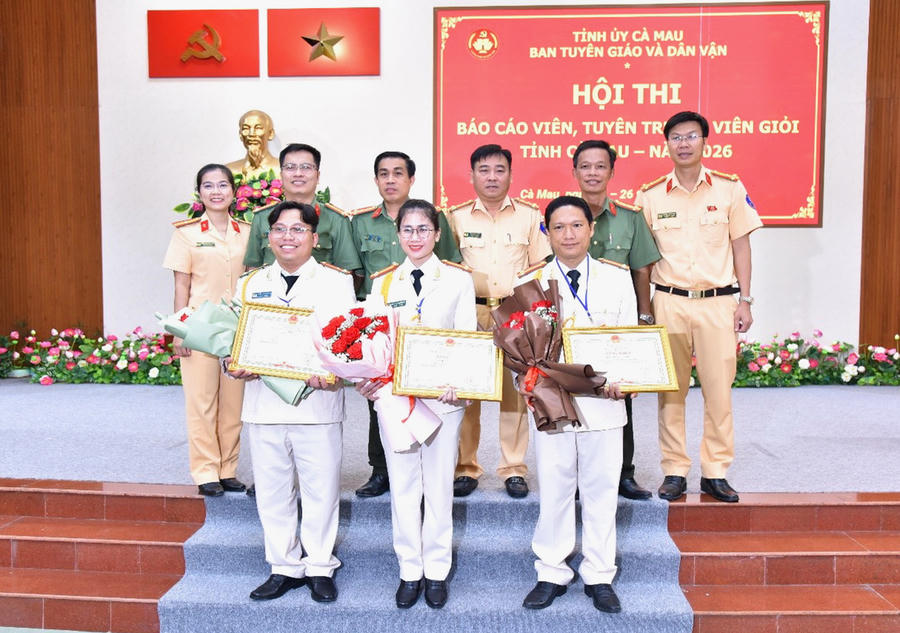 Trung tá Nguyễn Quỳnh Nga (đứng giữa, hàng đầu) chụp ảnh lưu niệm cùng đại diện Ban Giám đốc Công an tỉnh Cà Mau và Ban Chỉ huy Phòng Cảnh sát giao thông tại lễ bế mạc, trao giải Hội thi Báo cáo viên, tuyên truyền viên giỏi cấp tỉnh năm 2026.