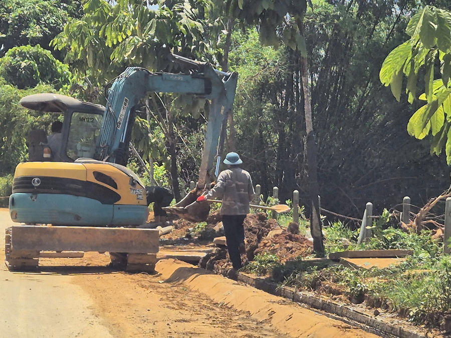 Công nhân và máy múc thu dọn đất rơi vãi, khơi thông hệ thống thoát nước sau phản ánh của Báo Pháp luật Việt Nam.