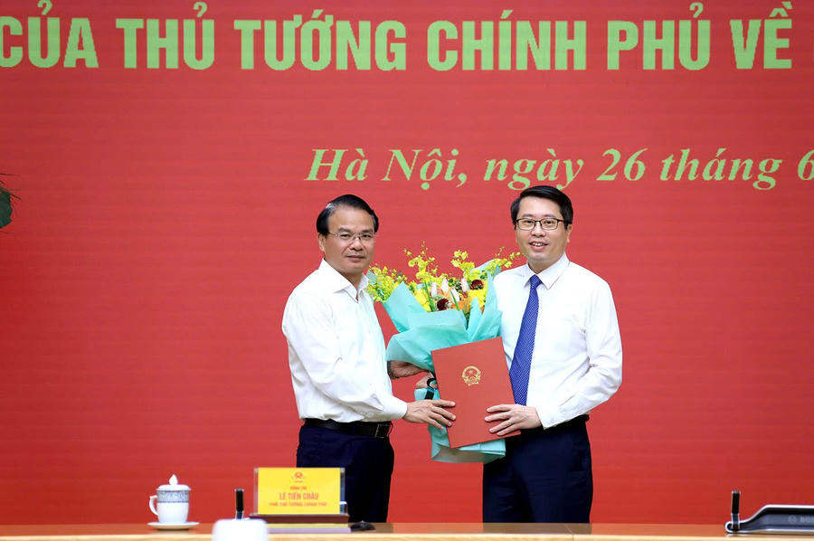 Bộ trưởng, Chủ nhiệm Văn phòng Chính phủ Đặng Xuân Phong tặng hoa chúc mừng Phó Chủ nhiệm Văn phòng Chính phủ Trần Anh Tiến - Ảnh: VGP