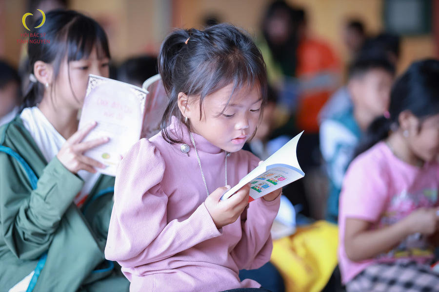 Các em học sinh đọc sách do đoàn thiện nguyện trao tặng. Ảnh Quách Quỳnh