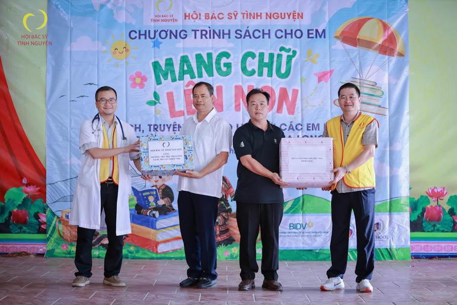 Đại diện Hội bác sĩ tình nguyện và Trung tâm Nhiệt đới Việt - Nga trao tặng sách và quà tặng cho nhà trường. Ảnh Quách Quỳnh