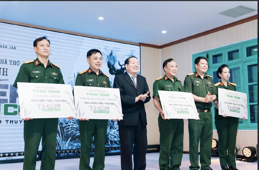 Nhà thơ Hữu Thỉnh và đại diện Nhà xuất bản Quân đội nhân dân tặng sách cho các đơn vị trong quân đội.