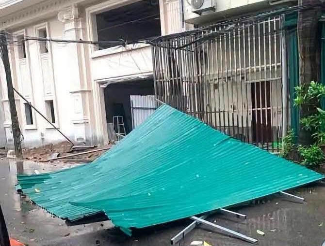 Gió bão quật đổ mái tôn nhà dân, nhiều cây xanh bị gió mạnh quật đổ, cành lá vương vãi trên mặt đường sau ảnh hưởng của bão số 1.