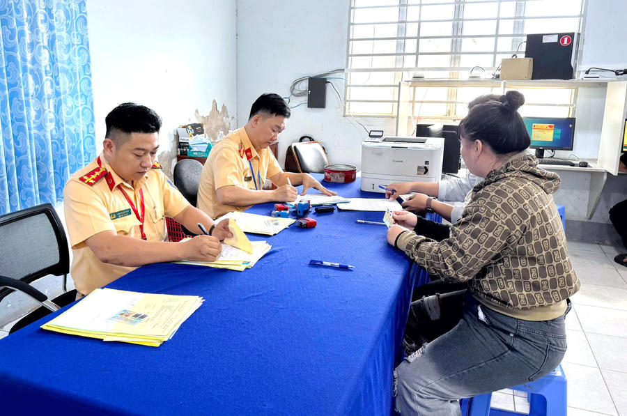 Cán bộ Phòng CSGT Công an tỉnh Cà Mau hướng dẫn, tiếp nhận hồ sơ đăng ký dự sát hạch giấy phép lái xe cho người dân.